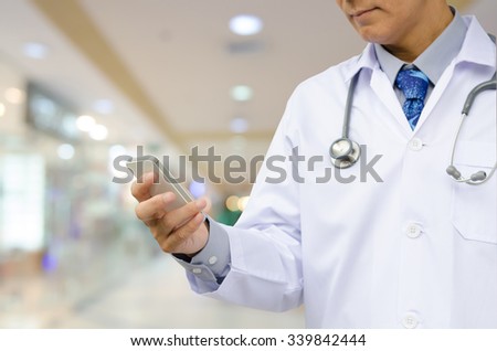 Doctor using mobile smart phone with blurred hospital  background.