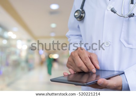 Doctor working on digital tablet computer in hospital. Electronic medical records system, electronic health records system, EMRs, EHRs concept
