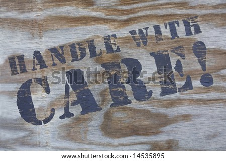 Close-up of handle with care sign on shipping carton.