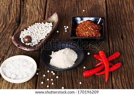 Peppercorn , milled  pepper,Cayenne pepper in ceramic cup  and Red peppers on old wooden table background