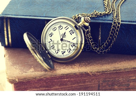 Vintage grunge still life with antique pocket watch, and old book