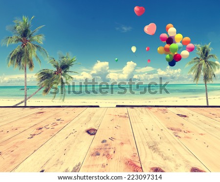 Vintage wooden floor with heart balloon on beach blue sky concept of love in summer and wedding honeymoon