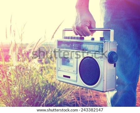 Man hand holding vintage radio on nature background