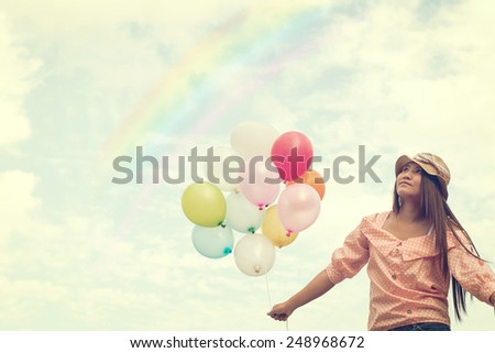 Vintage photo of  Happy young red hair woman  holding colorful balloons and flying on clouds sky background.