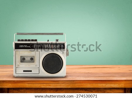 Old retro radio on table with vintage green eye light background