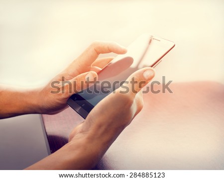 Close up of a business man using mobile smart phone   at wooden table with retro instagram filter effect