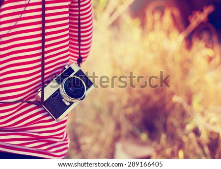 Vintage young hipster girl photographer with retro camera in holiday travel