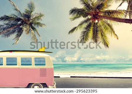 Vintage car in the beach with a surfboard on the roof