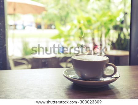 Cup of coffee on table in cafe Morning light , vintage or retro color toned