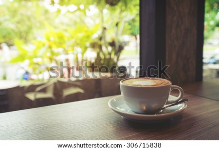 Cup of coffee on table in cafe Morning light , vintage or retro color toned