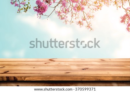 Top of wood table with pink cherry blossom flower on sky background - Empty ready for your product display or montage.