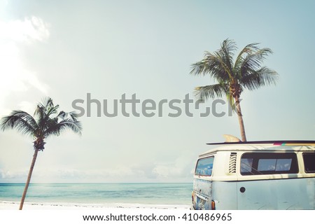 Vintage car parked on the tropical beach (seaside) with a surfboard on the roof - Leisure trip in the summer