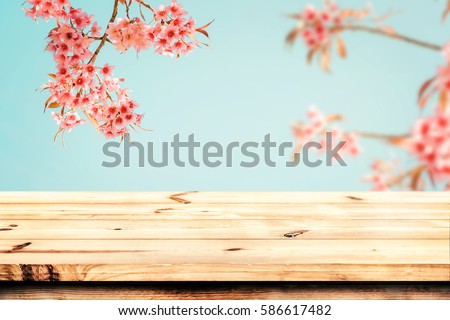 Top of wood table empty ready for your product and food display or montage with pink cherry blossom flower (sakura) on sky background in spring season. vintage color tone.