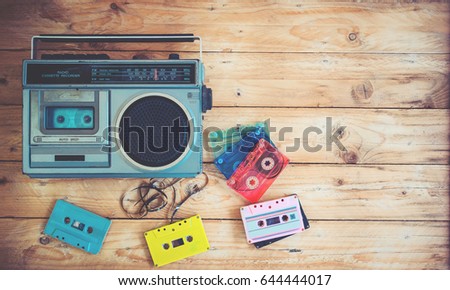 Top view hero header - retro technology of radio cassette recorder music with retro tape cassette on wood table. Vintage color effect styles.