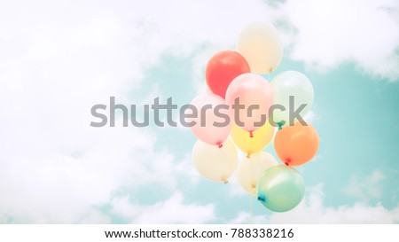 Vintage multicolor balloons with done with a retro instagram filter effect on blue sky. Ideas for the background of love in summer and valentine, wedding honeymoon concept.