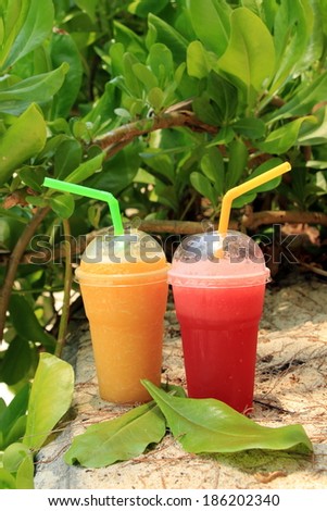 Different fresh juices in plastic cups. Mango juice, watermelon juice.