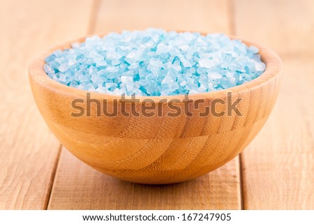 blue Sea salt crystals in a bowl on wood plank