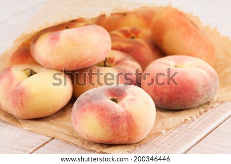 ripe juicy chinese flat peaches or Saturn peaches