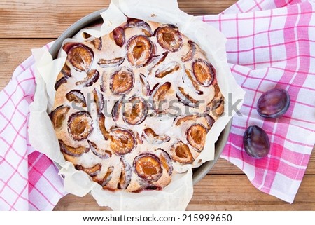 plum cake on a wooden background with fresh plums