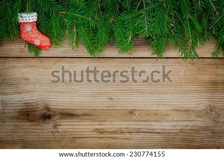 Pine tree border with red sock on old rustic wooden background