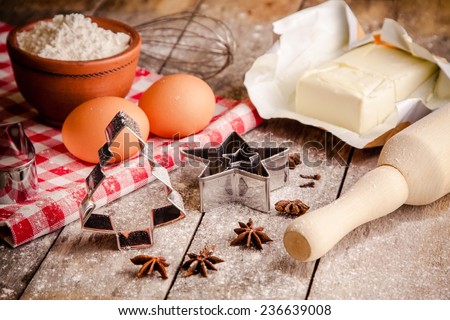 Baking ingredients - flour, eggs, butter and rolling pin, cookie cutters on a table