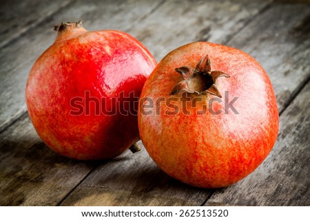 two ripe pomegranate on a wooden rustic background