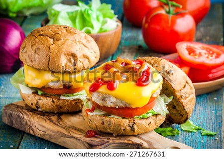 homemade burgers with chicken cutlet, cheddar cheese, fresh tomatoes and lettuce