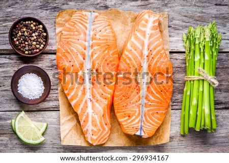 fresh raw salmon fillet with asparagus and lime on the wooden table