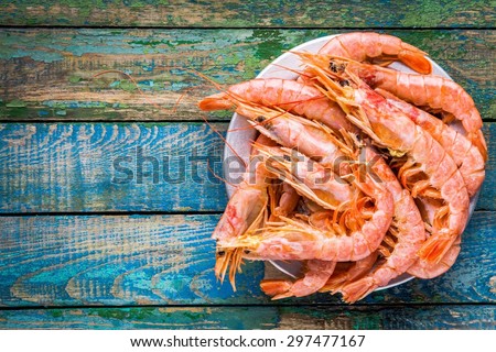 fresh raw shrimps in a bowl on a wooden table