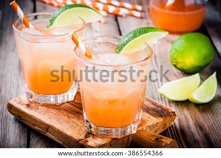 Alcohol tequila sunrise cocktail with ice and lime