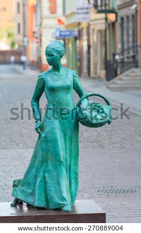 TORUN, POLAND - APRIL 2015: Torun, Statue of woman baker (polish: Piernikarka) placed in 2011 on Garbary \
street