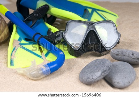 mask, fins and tube in sand background