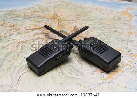 Two black compact professional portable radio sets with maps
