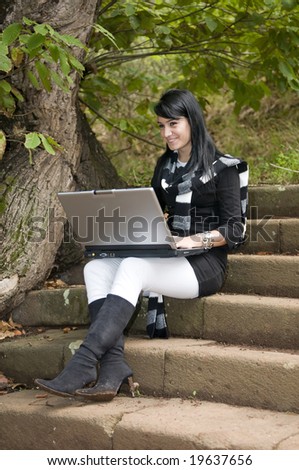 woman working with portable laptop in the forest