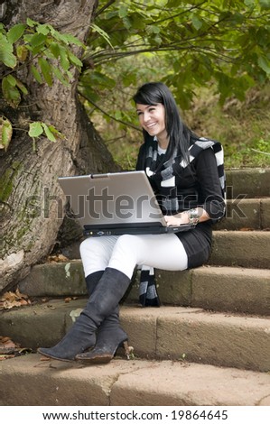 woman working with laptop in the forest