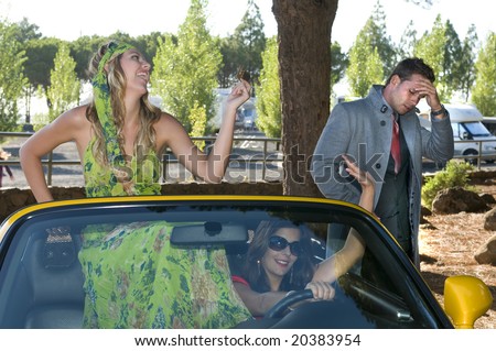 women running in an sport car with a credit card of a desolated man