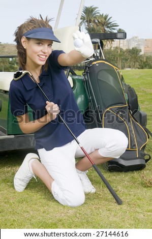 A pretty woman golfer holding a golf ball