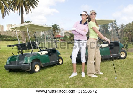 two pretty golf player with her golf cars