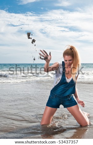 naughty woman at the seaside throwing sand