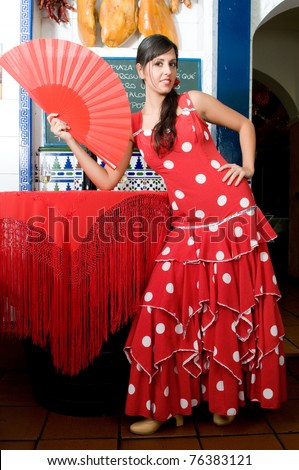 stock photo : woman in typical spanish restaurant with flamenco dresses and jam