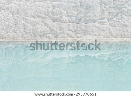 background picture of white travertine wall reflecting in turquoise mineral pool in Pamukkale, Turkey