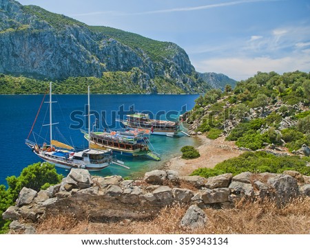 view of three tourist boats at Camellia island in Aegean Sea from medieval wall ruins with mountains at background, Marmaris Turkey