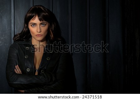 Sexy brunette in a leather jacket with dramatic lighting.