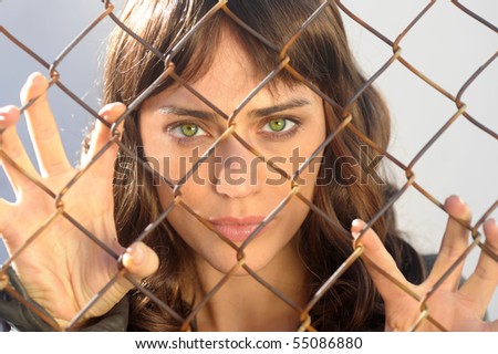 Beautiful woman trapped behind a fence