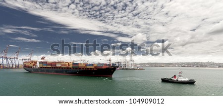 Cargo ship with tug boat assistance leaving the port of Durban South Africa