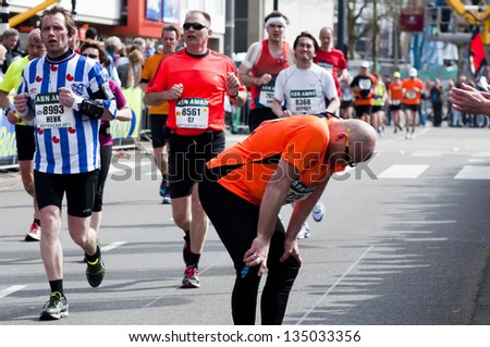 ROTTERDAM, THE NETHERLANDS - APRIL 14 : Exhausted runner giving up during the Annual Fortis Rotterdam Marathon. Runners on the city streets on April 14, 2013 in Rotterdam, The Netherlands.