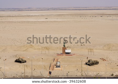 a war memorial statue in Suez Canal and tanks