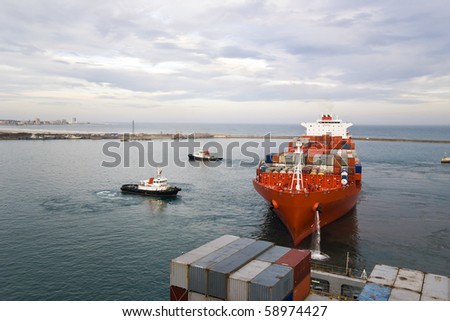container vessel and a small tugs, manoeuvring scene (no logos on the photo)