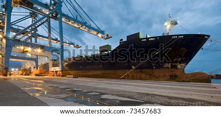 Cargo ship loading containers by night