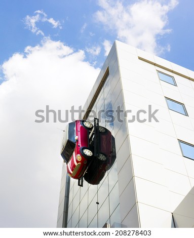Athens, Greece - July 27, 2014: BMW Mini One shop on Leof. Andrea Siggrou. This is a view of a full size Mini one car suspended vertically against the wall of the shop above the window.